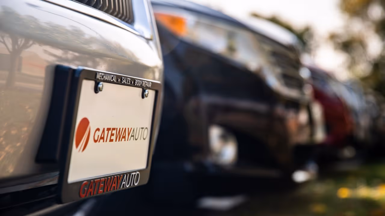 A close-up view of a Gateway Auto license plate on one of several cars for sale 