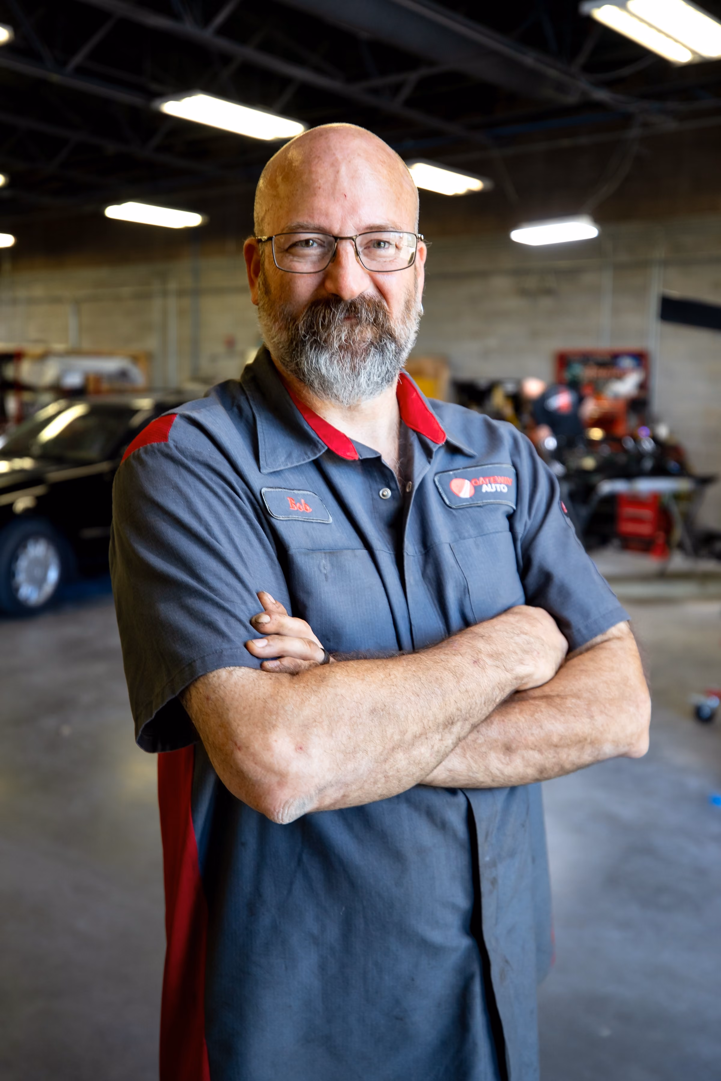 A Gateway technician working on a car on the lift