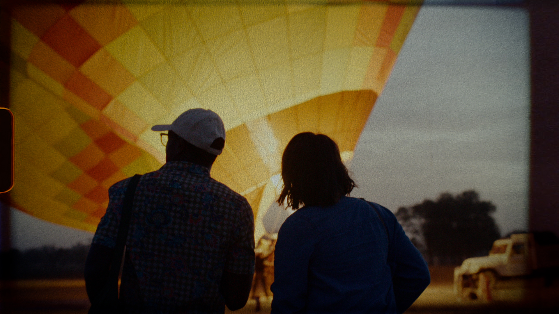 This Is Intrepid, two travellers watching a hot air balloon inflate