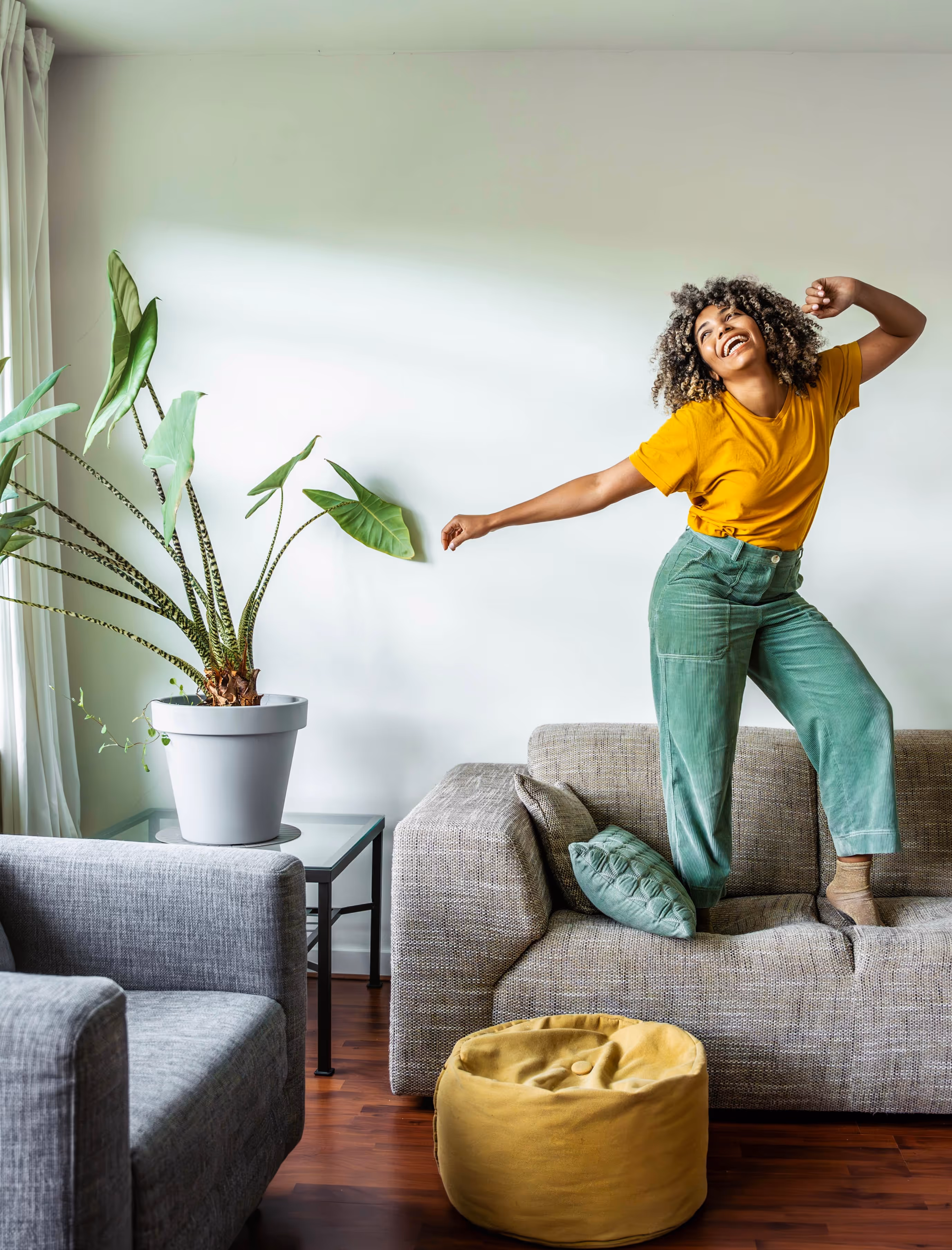 Woman dancing on her couch at home