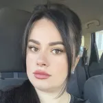 A woman sitting in the back seat of a car.