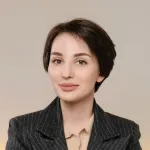 A woman in a business suit posing for a picture.