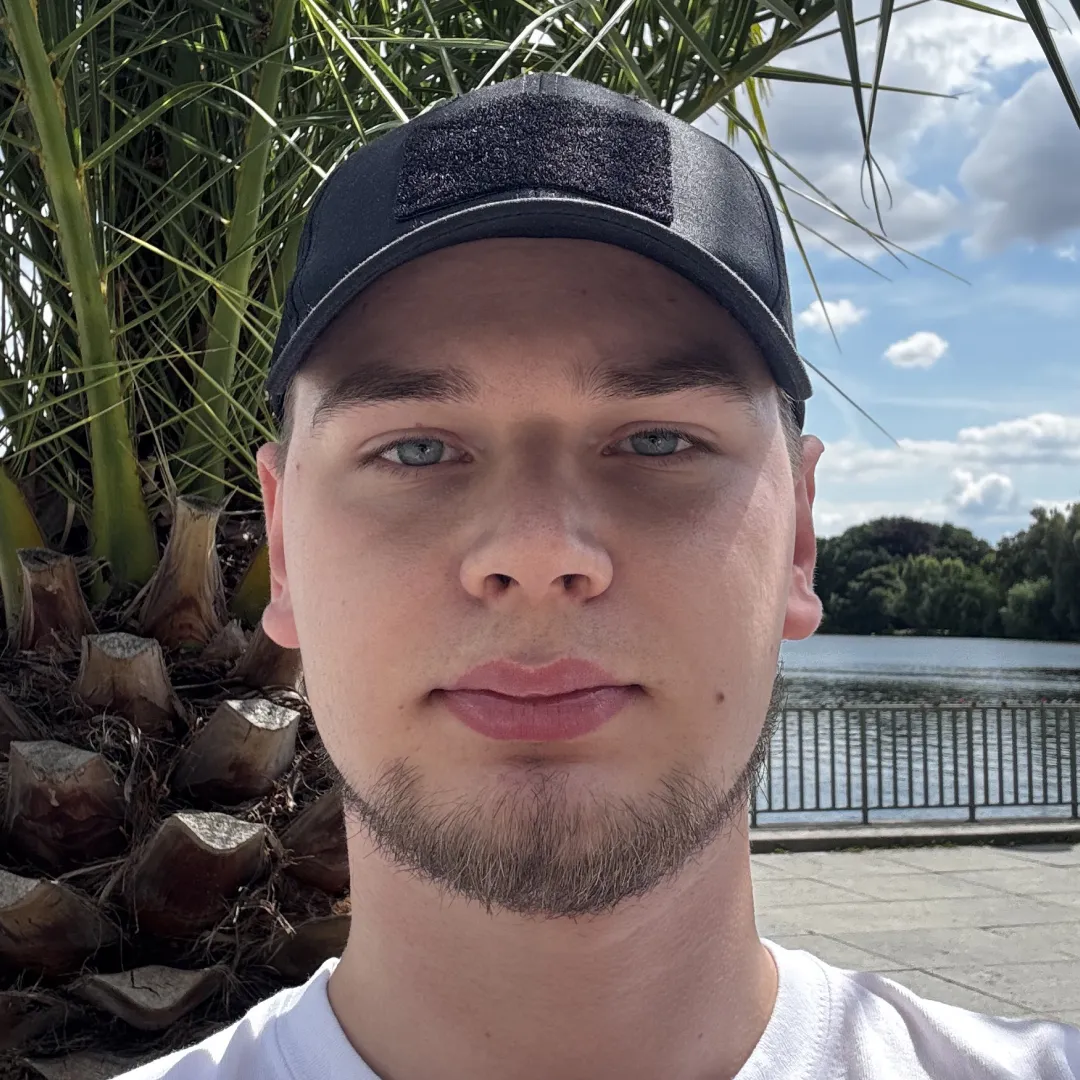 A man wearing a hat and a white shirt.