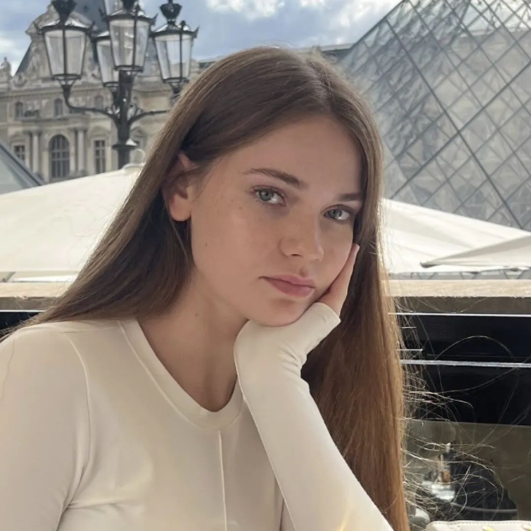 A woman sitting at a table in front of a building.
