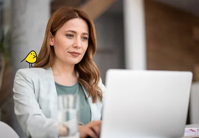 woman sitting at laptop with canary
