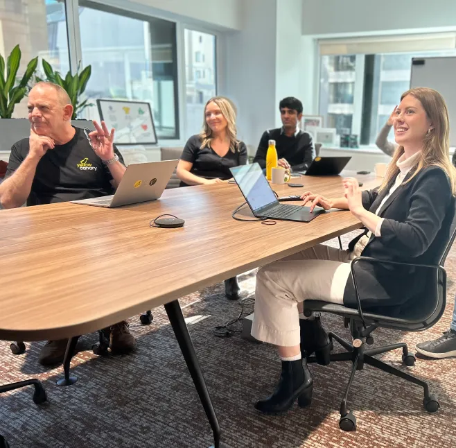 Two people working at their desks and laughing.