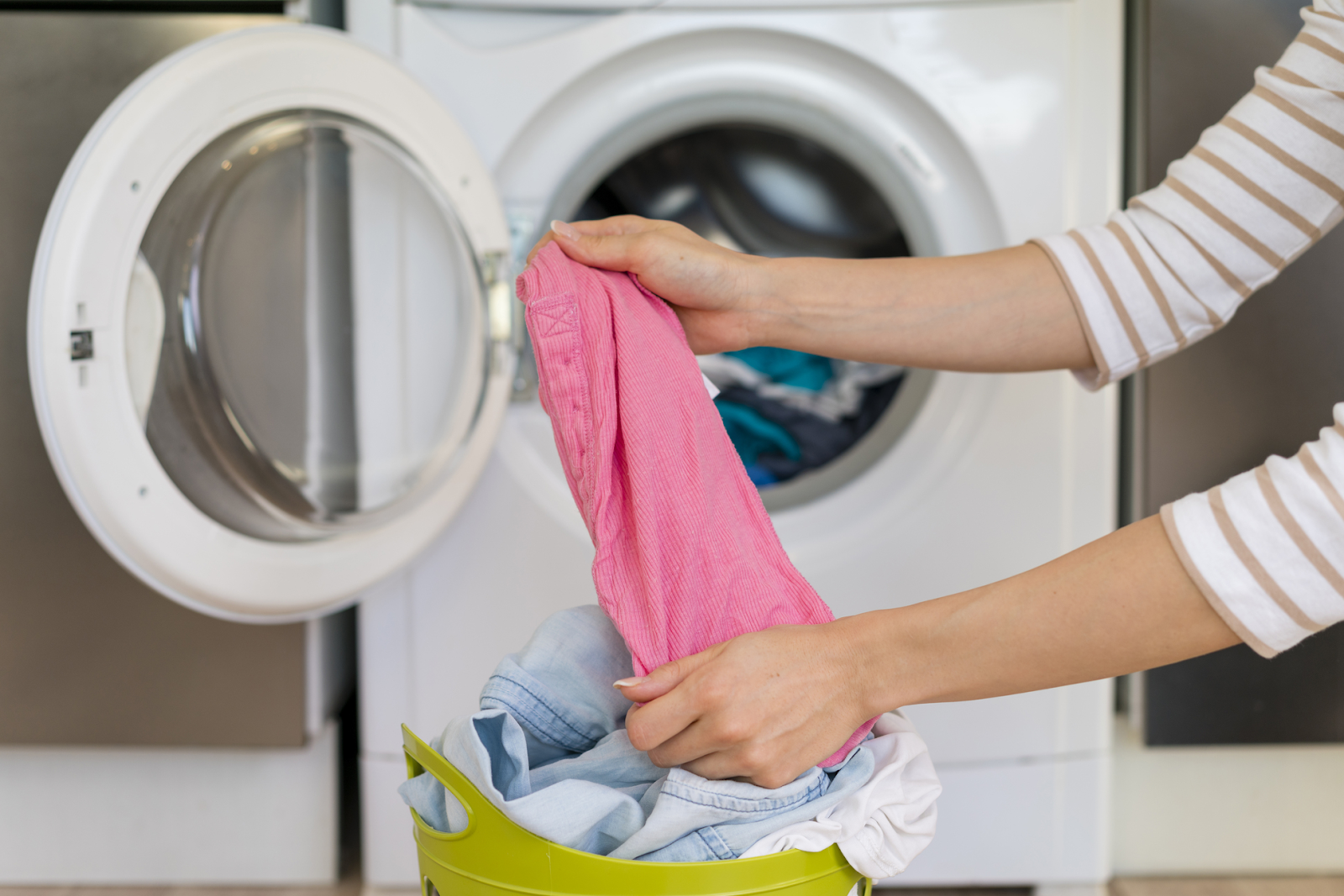 putting clothes into washing machine