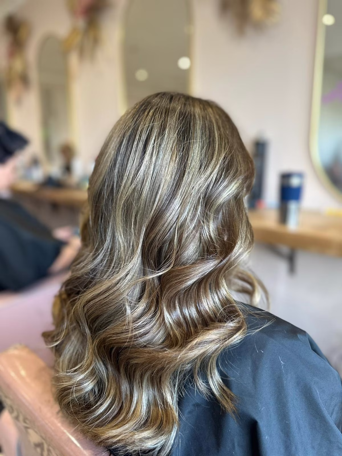 Brunette with balayage highlighting, styled with loose curls
