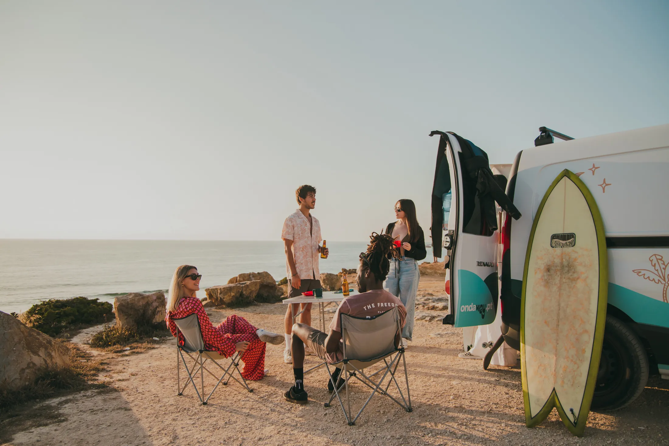 friends sitting together at cliff