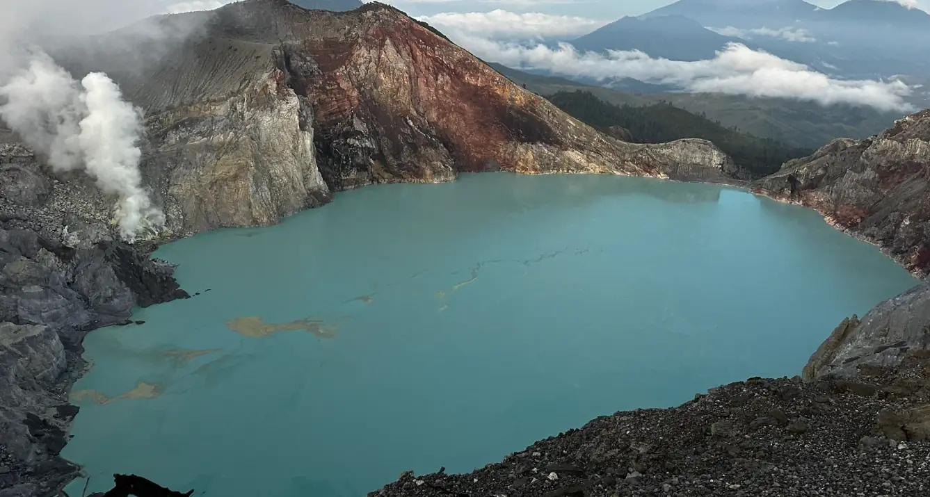 The turquoise crater lake at Mount Ijen after sunrise