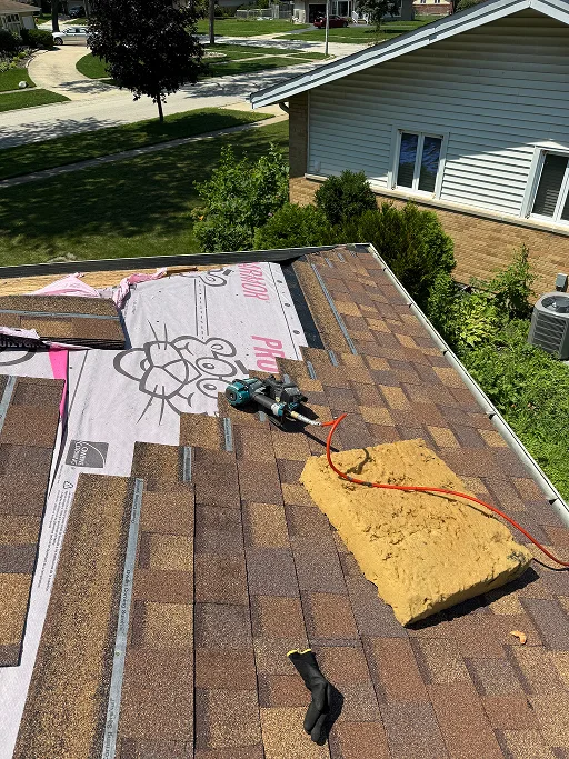 Roof Replacement in Progress with New Shingles, Underlayment, and Tools on Site