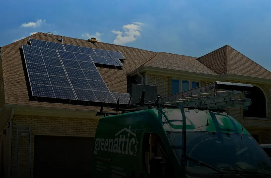 Solar panels installed on a residential roof with Green Attic service van in front