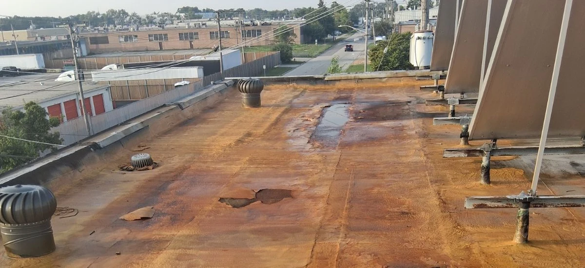 Commercial Flat Roof in Schiller Park with Rust-Colored Surface and Water Damage