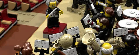 LEGO conductor with gray hair leading an orchestra of LEGO musicians playing brass and wind instruments.