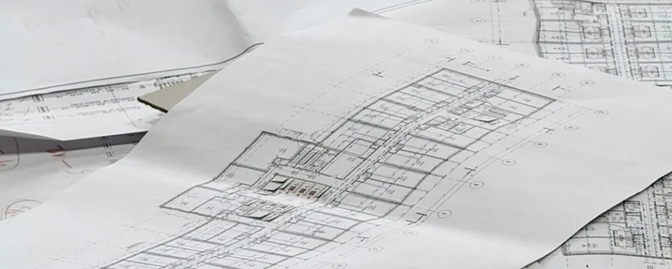 Close-up of architectural blueprints with floor plans spread out on a table.