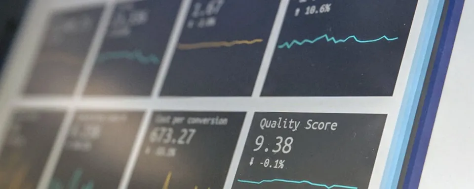 Close-up of a digital dashboard displaying metrics including a quality score of 9.38 with a -0.1% change and cost per conversion of 973.27.