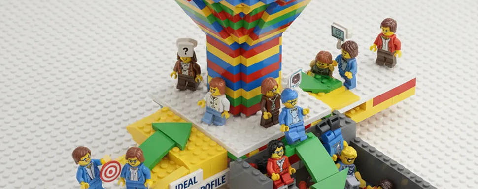 Lego figures on colorful block structure with green arrows showing movement paths around them.