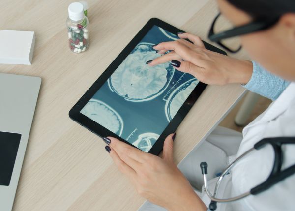 Doctor scrolling through medical images on a tablet. 