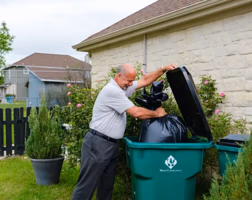 Stacked cardboard boxes on a recycling bin for commercial waste disposal services.