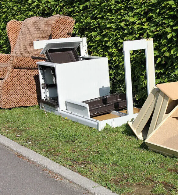Stacked cardboard boxes on a recycling bin for commercial waste disposal services.