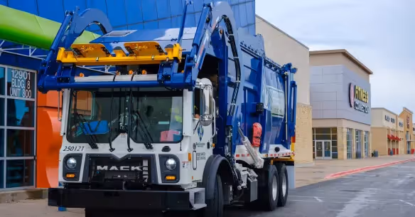 Stacked cardboard boxes on a recycling bin for commercial waste disposal services.