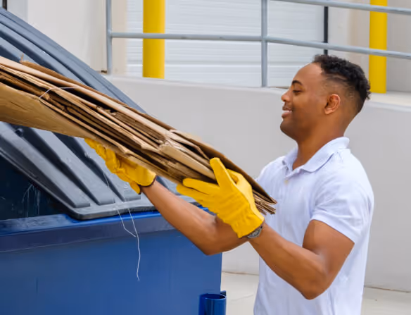 Stacked cardboard boxes on a recycling bin for commercial waste disposal services.