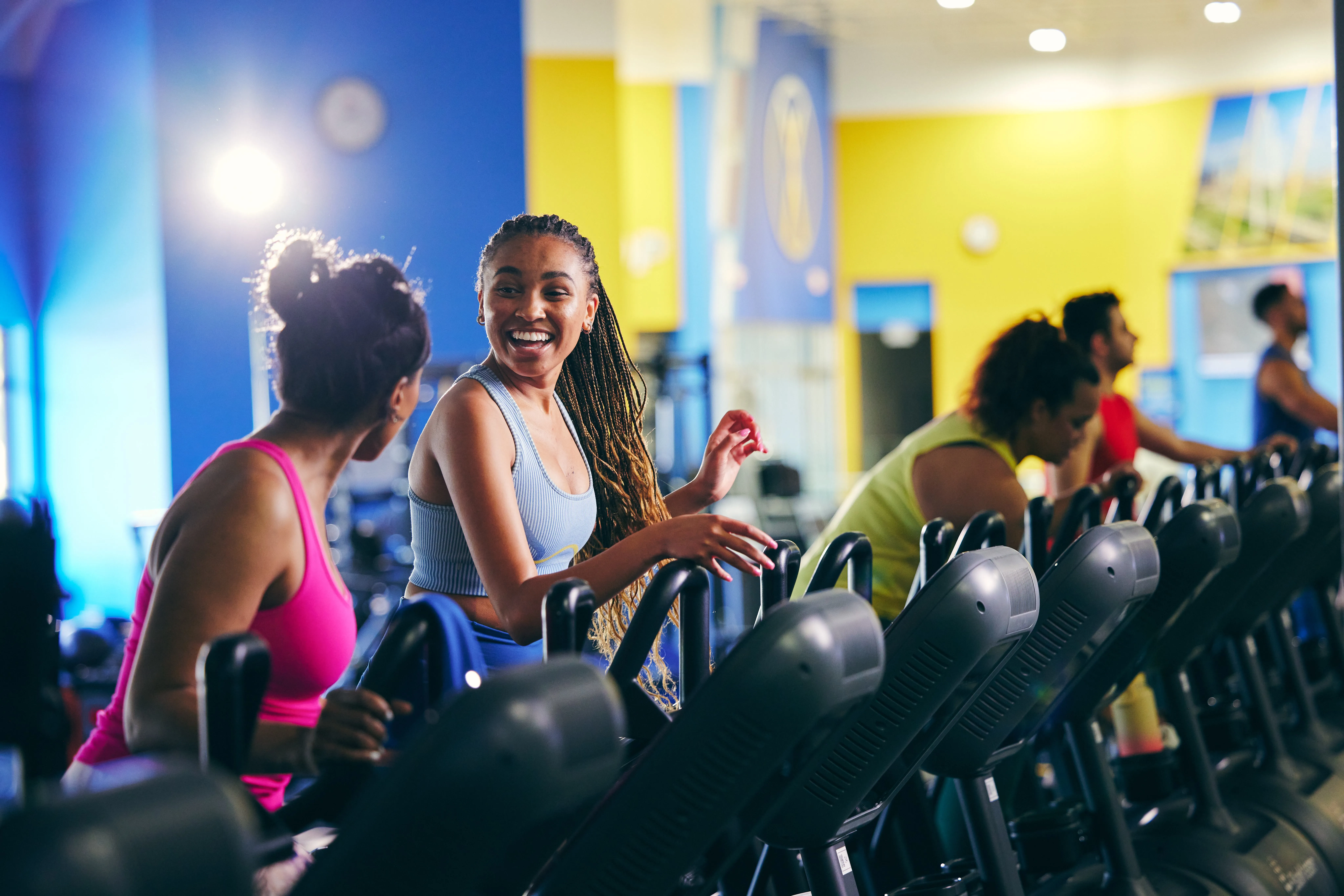 Two women on treadmills talking.