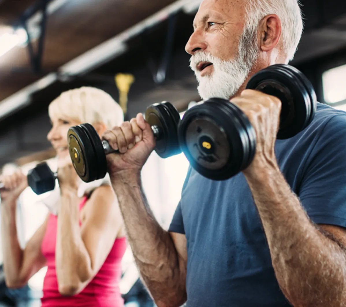 An older man and woman using dumbbells to workout