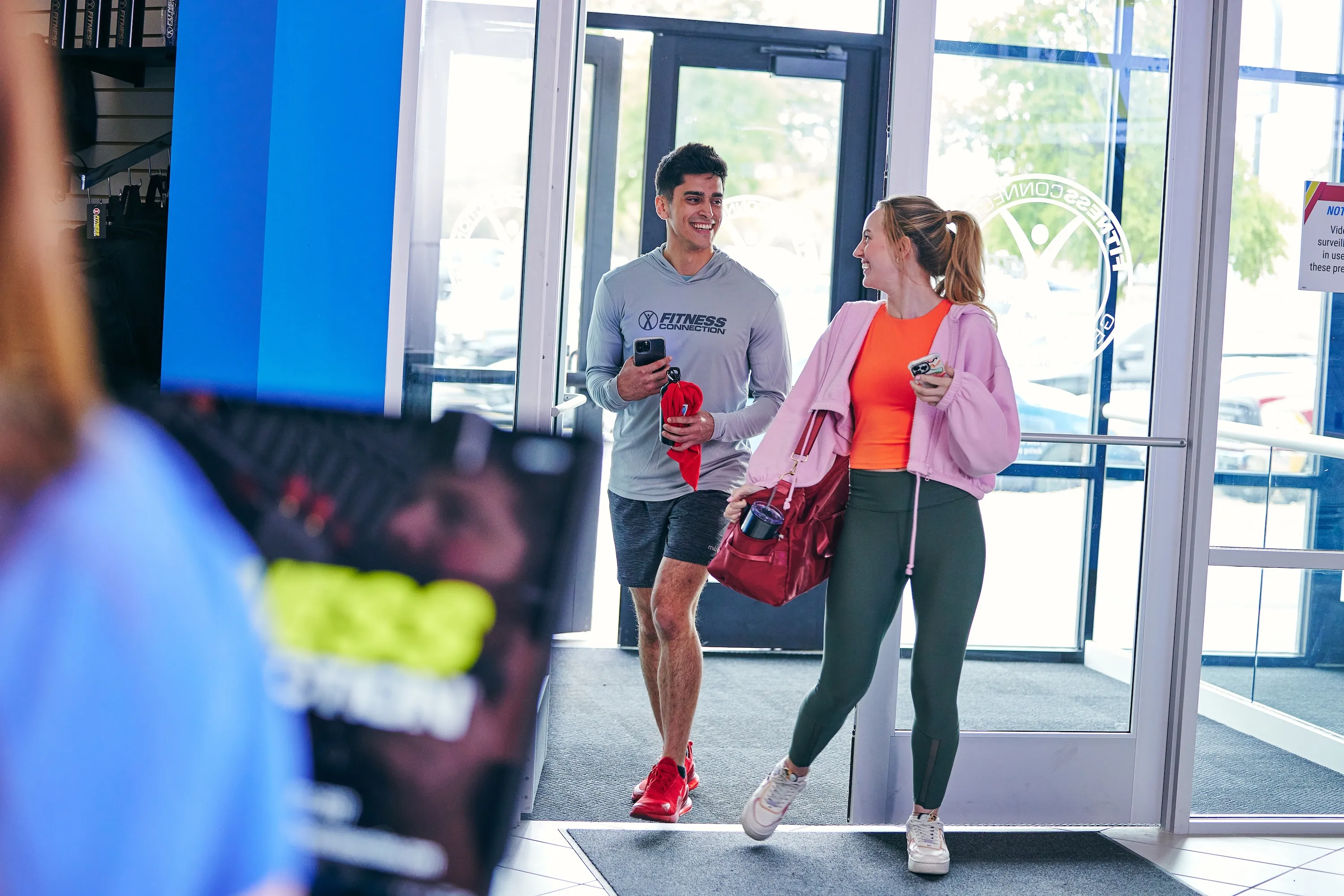 Young man and woman walking into a Fitness Connection gym