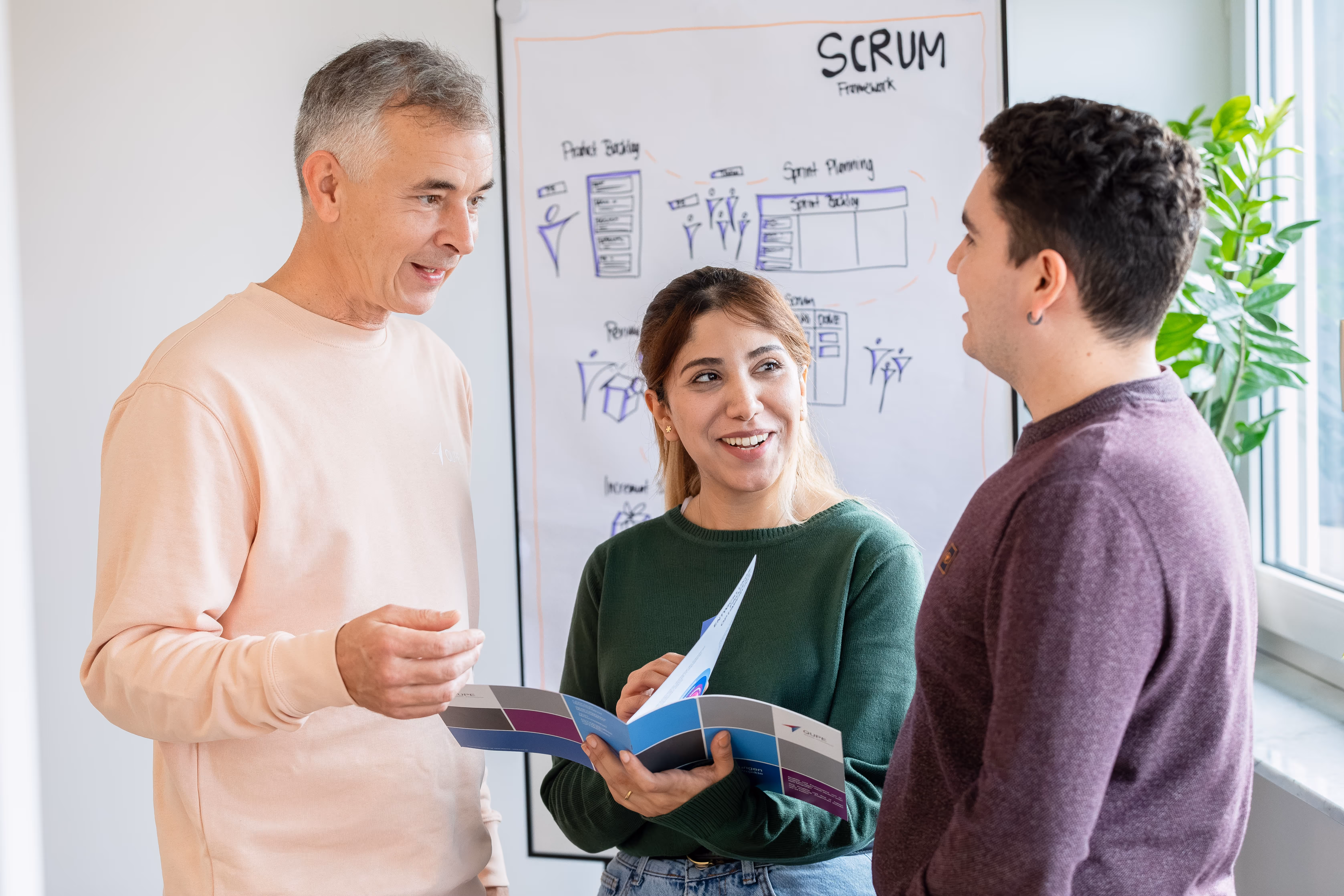 Zwei Personen sitzen auf einer Couch, wobei eine Person einen Laptop hält und dem anderen etwas zeigt.