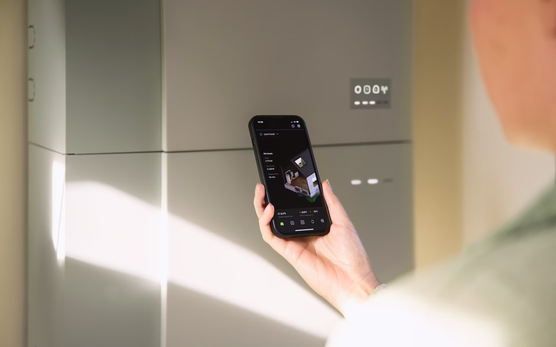 Een Quatt Hybrid Single warmtepomp, geplaatst op trillingsdempers in een grindtuin tegen een rode bakstenen muur.