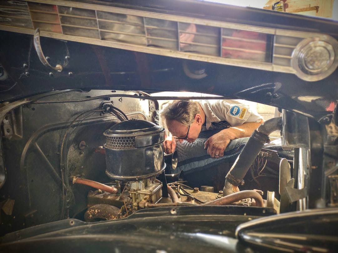of a mechanic inspecting an engine bay - vehicle repair cost