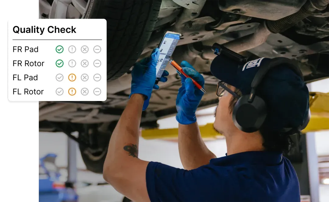Experienced mechanic inspects a vehicle's front brake rotor and caliper on a lift, with fresh brake pads and tools arranged nearby in a clean Omaha auto repair shop.