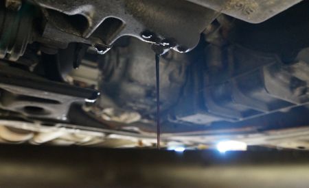 Oil drain during an oil change, seen from under the vehicle