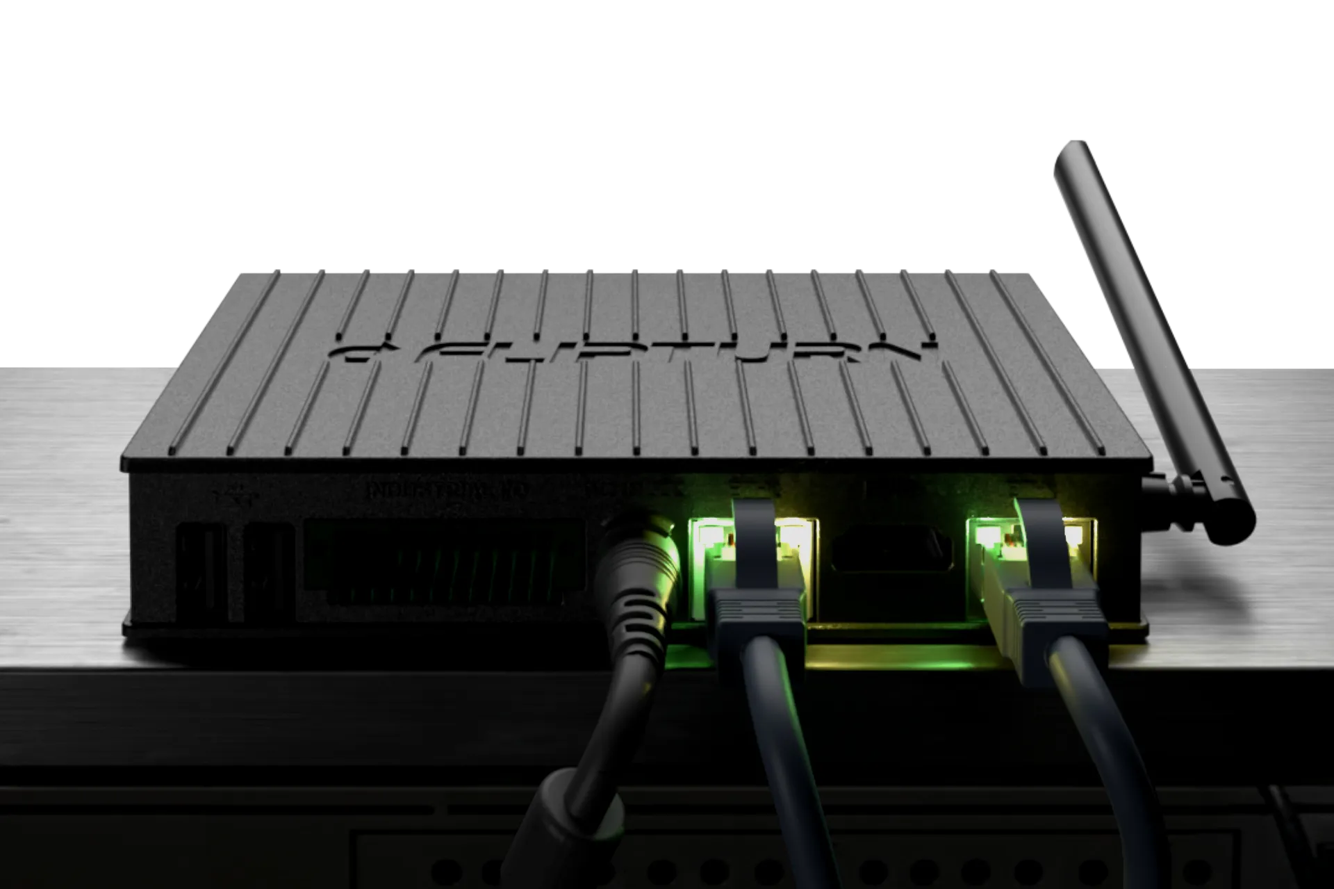 Close-up of Flipturn's onsite controller device with two Ethernet cables and a power cable connected, with glowing green indicator lights.