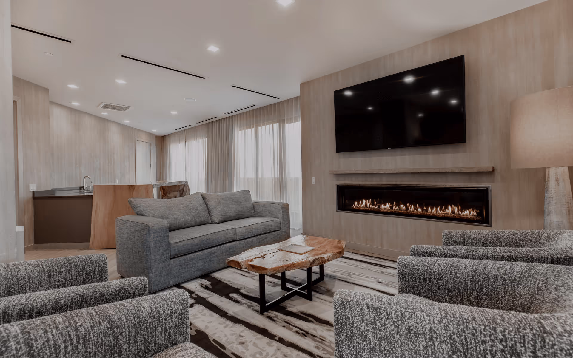 Terrace Suite living room with couches a large TV on the wall with a electric fireplace below