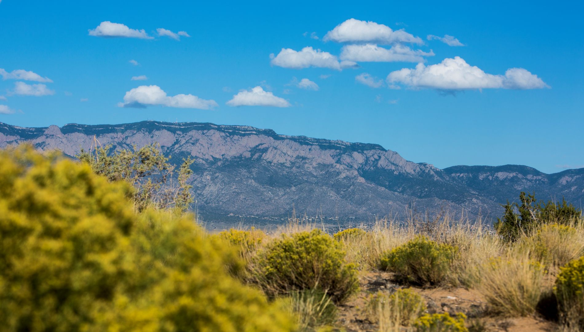 Sandia mountains with bright blue sky and clouds