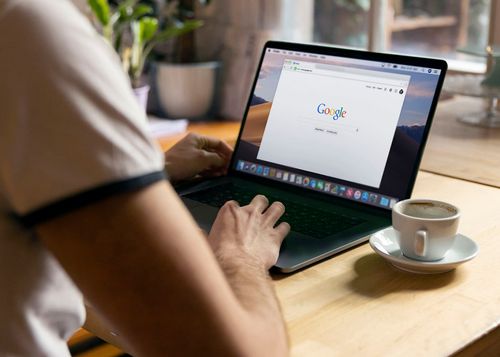 someone using a laptop with google.com on the screen