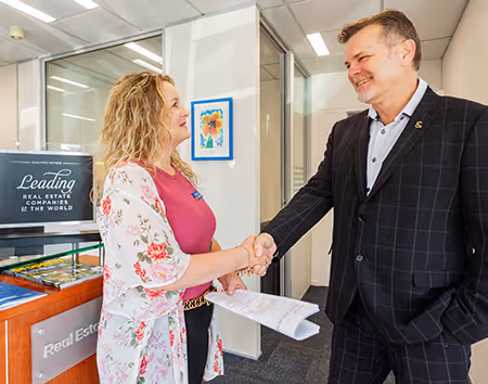 Manager shaking the hand of one of his real estate agents who has just sold a propeprty