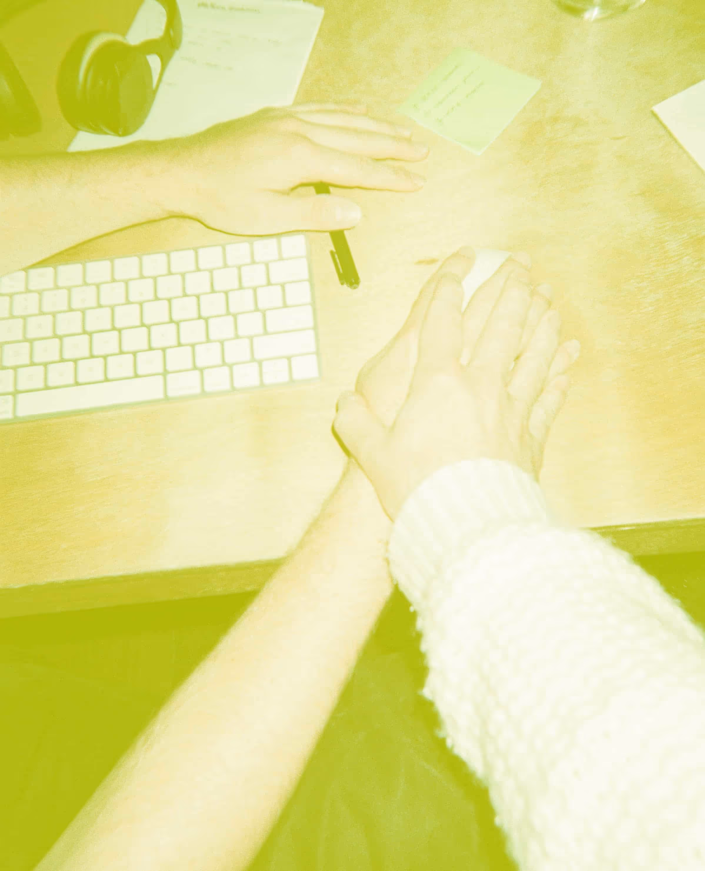 Two hands on a computer mouse, overlaid by a yellow filter.