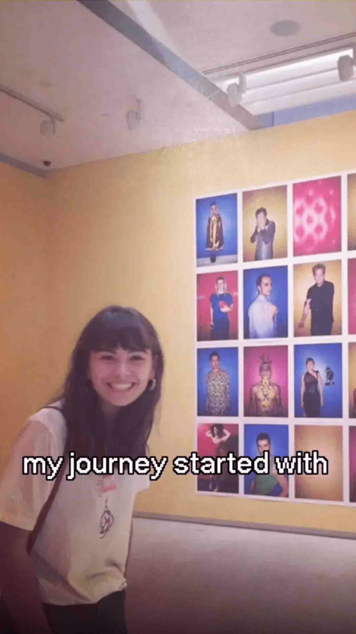 A woman smiling in front of a colourful portrait wall in a gallery space, with on-screen text that reads 'my journey started with'.