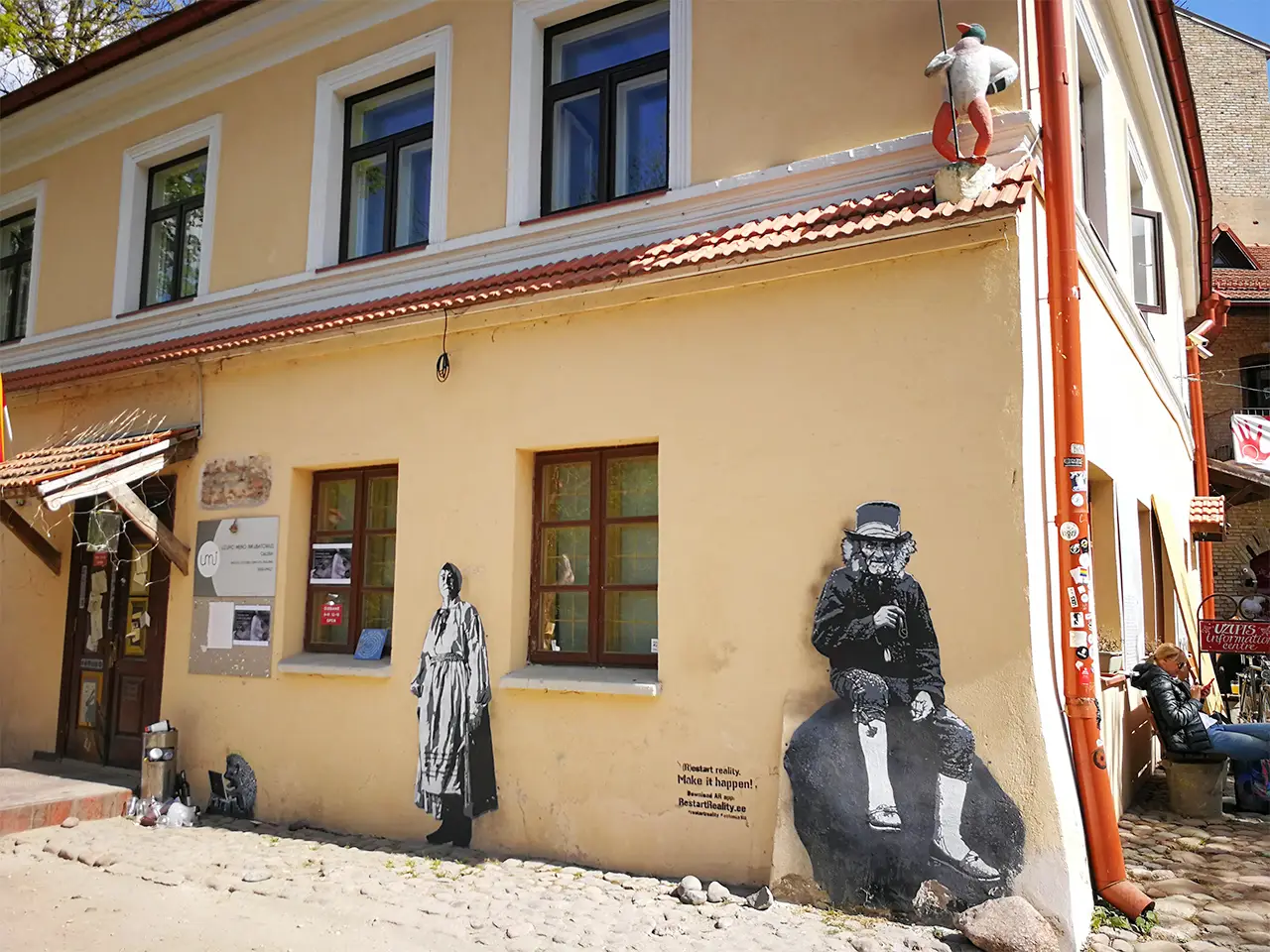 Стара романтична жълта къща с черно-бели графити по фасадата си