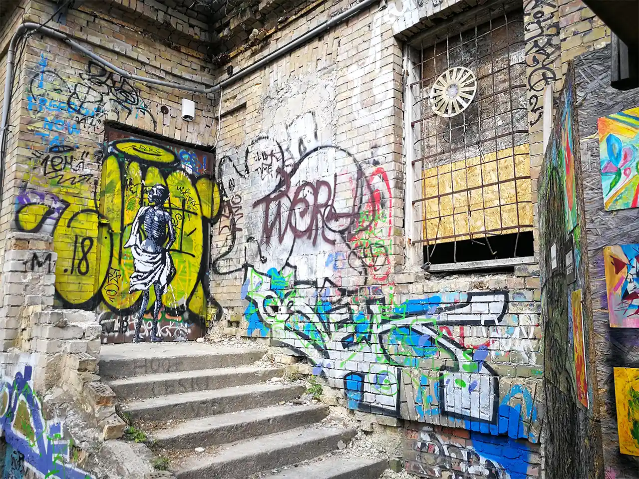 Преобразена от свободно изкуство и пъстри бунтараски надписи фасада на необитаема сграда