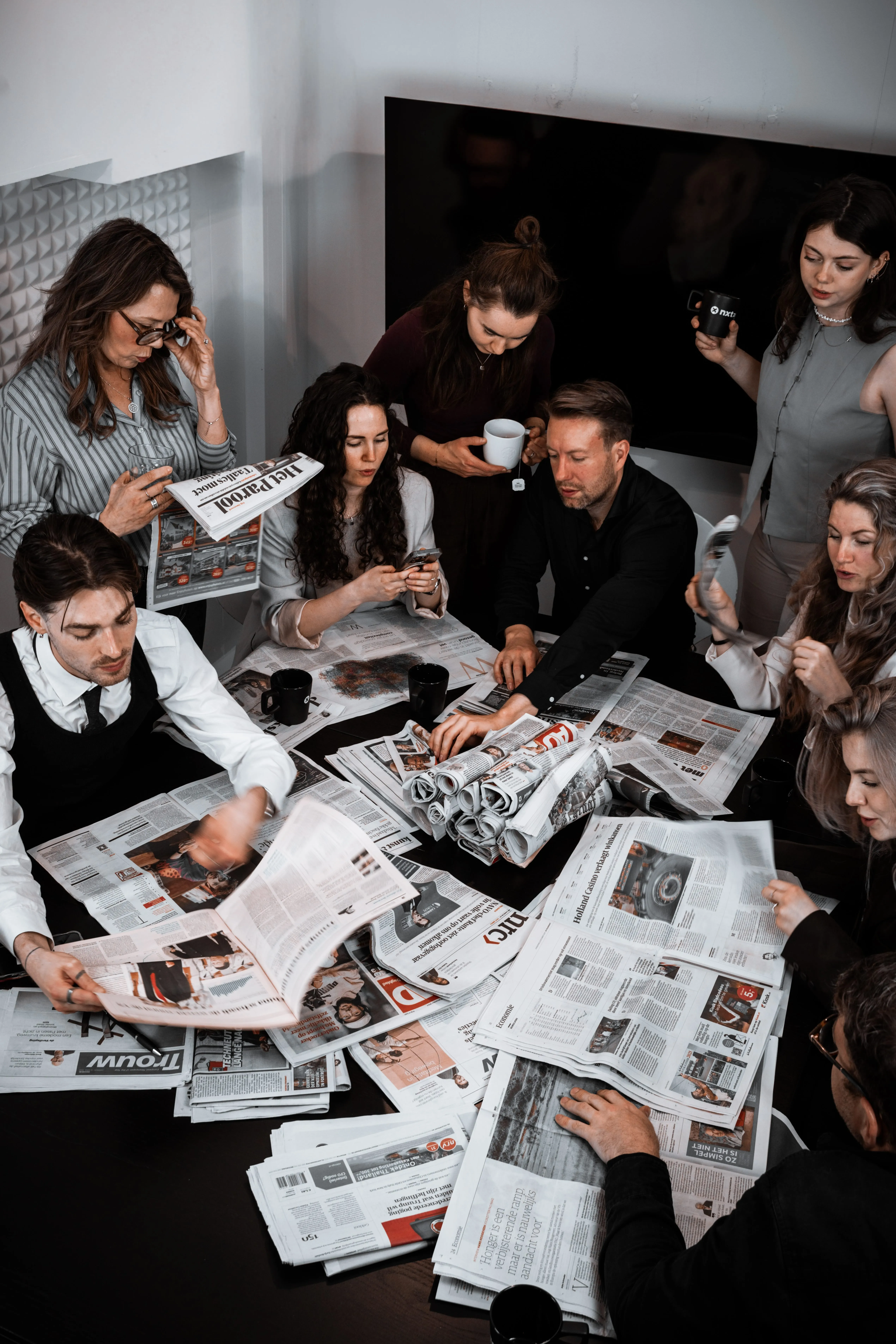 Pr experts Remi en Donna lezen samen de krant opzoek naar relevante en actuele informatie voor de mediatraining