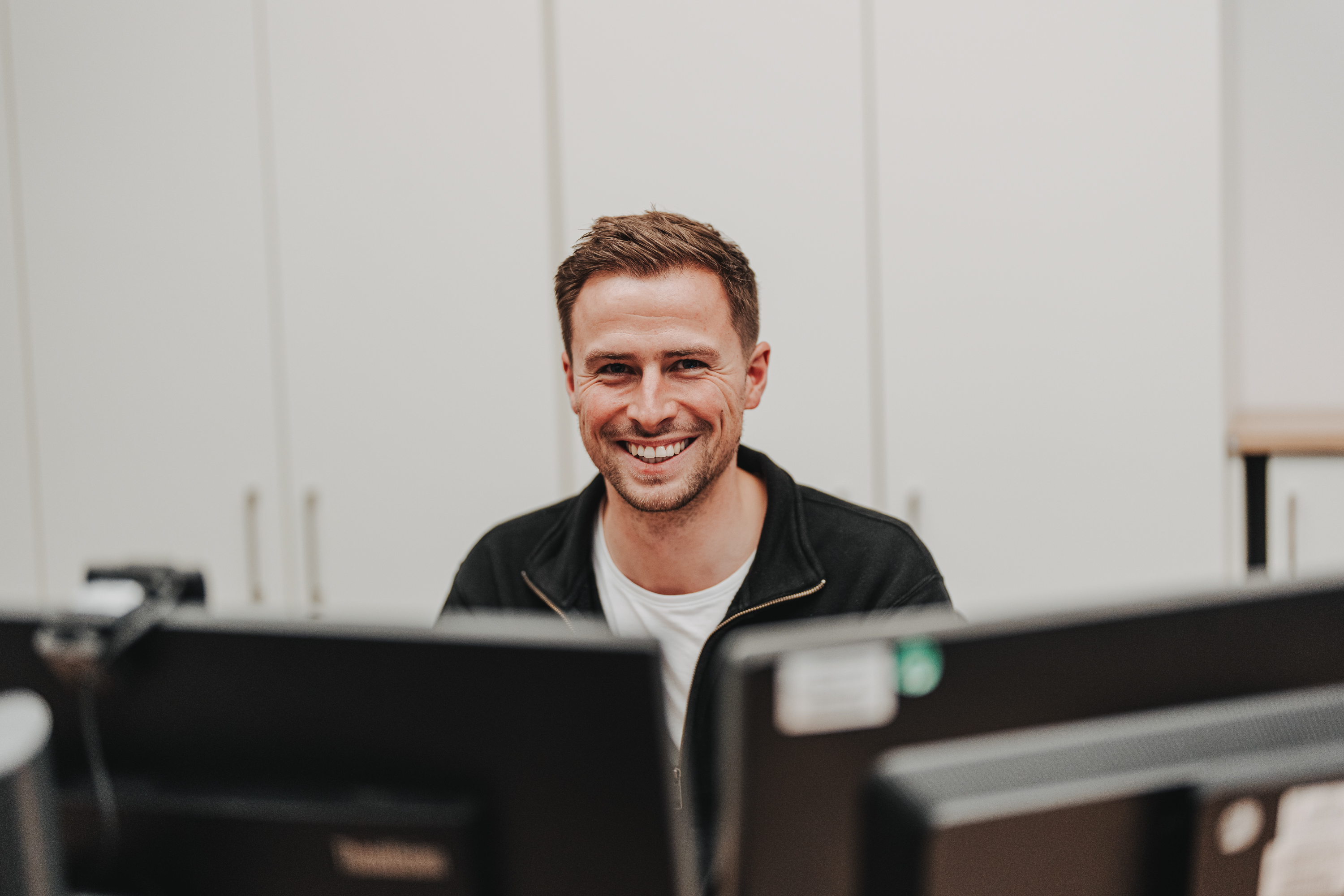 ENERCON Büroarbeitsplatz mit modernen Glasräumen und Besprechungsbereich; zeigt administrative Aufgaben, Koordination und mobiles Arbeiten