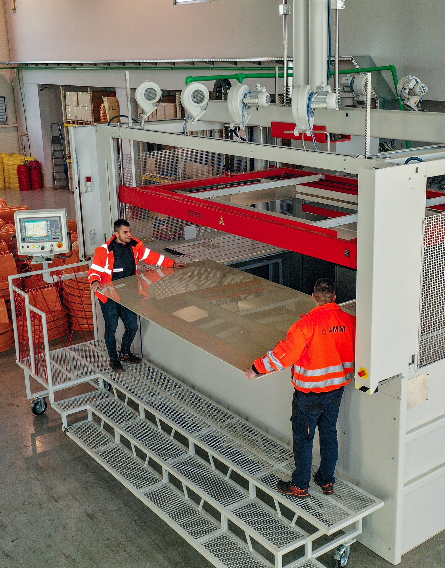 Thermoforming press machine and two workers handling the machine