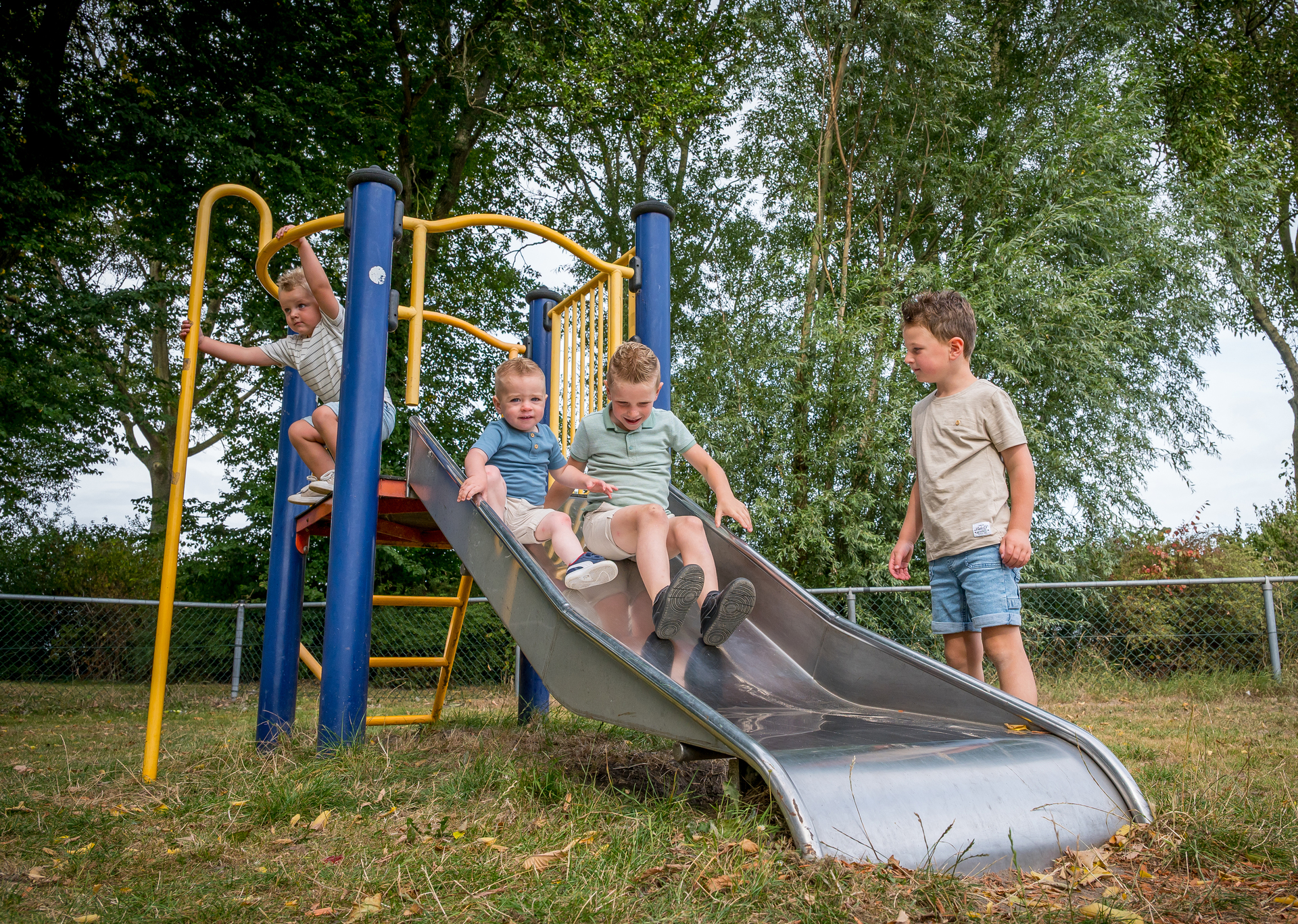 Een ABOS-medewerker en een klein meisje staan op een houten steiger bij een meer