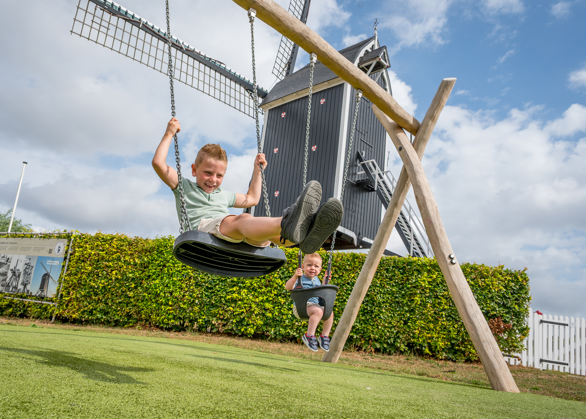 Een houten speeltoestel met spelende kinderen op een schoolterrein