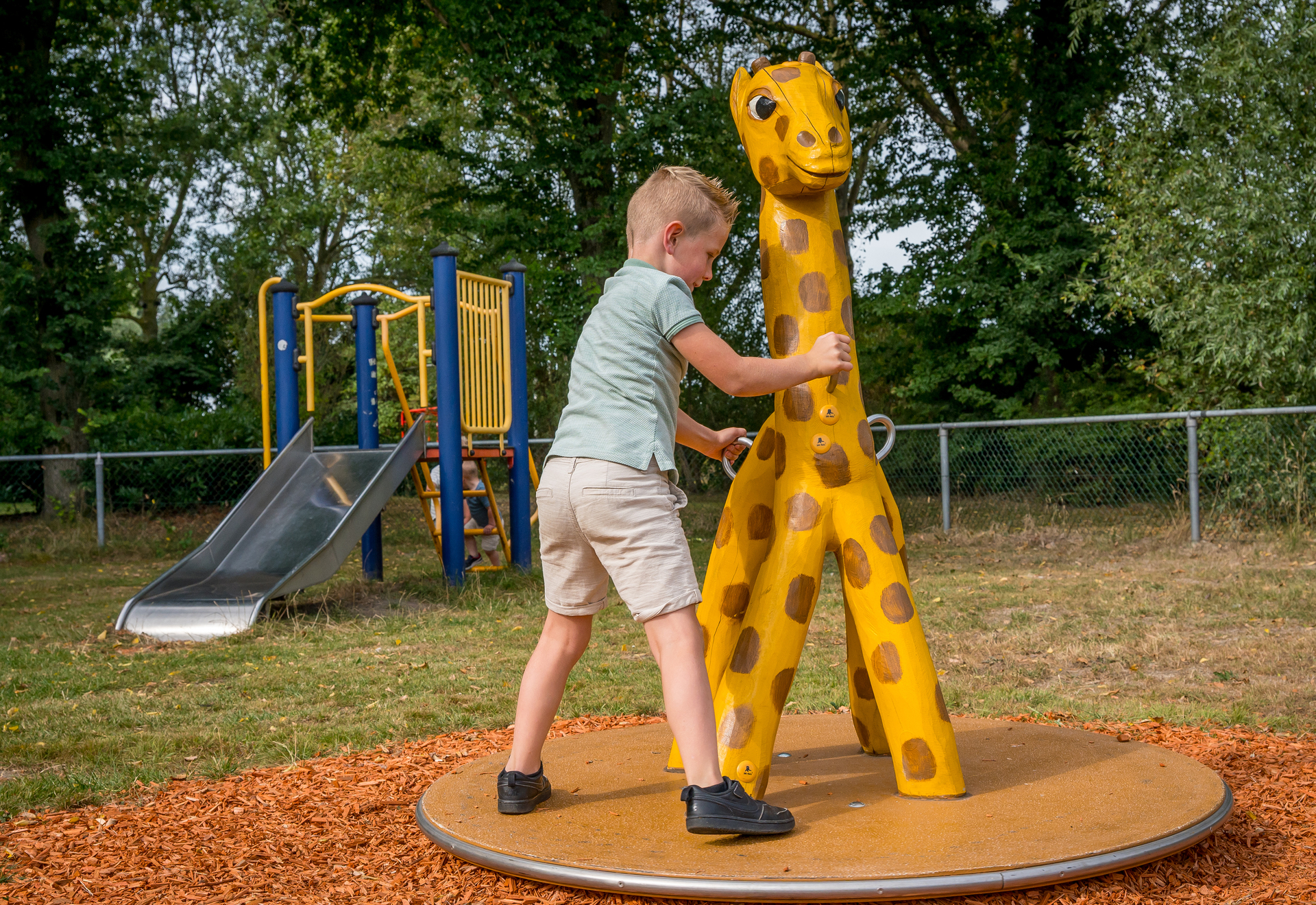 Een jongen glijdt van een glijbaan