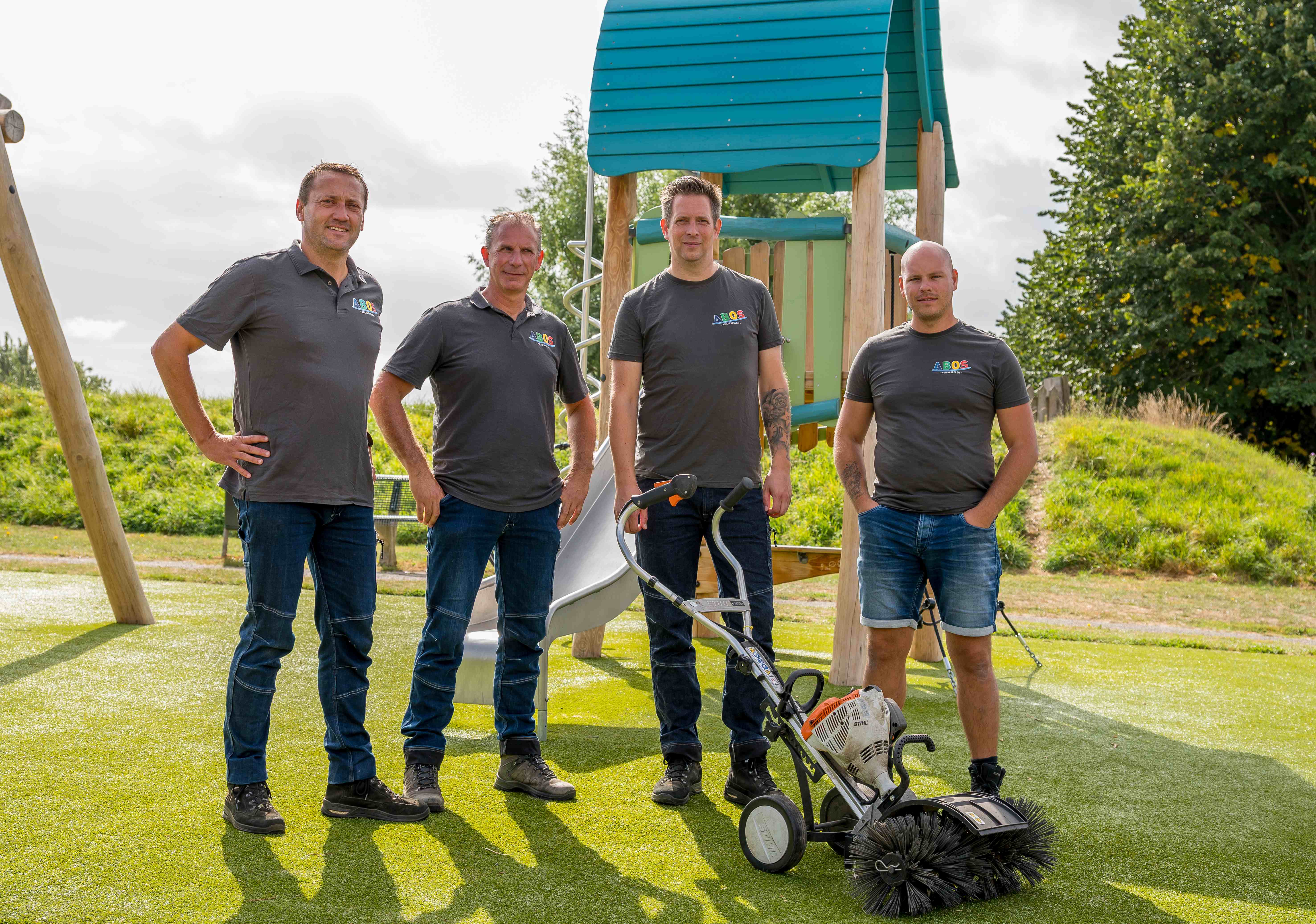 Een glimlachende ABOS-medewerker staat op een houten aanlegplaats met een inspectie toestel in zijn handen